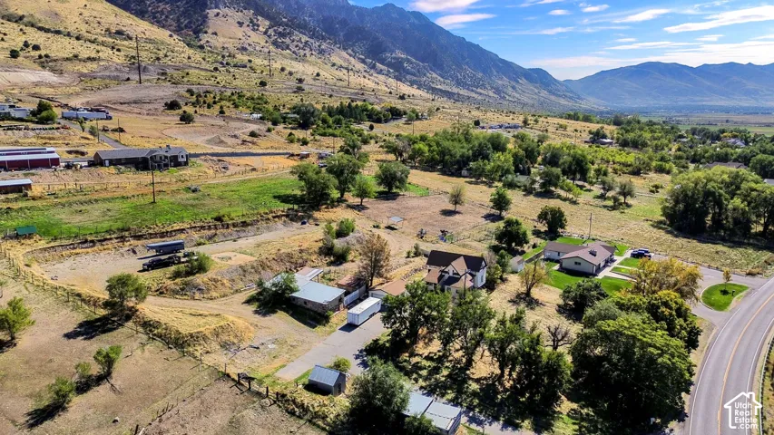 Mountainous terrain, rural setting, paved road access, multiple dwellings, mature trees