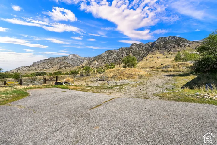 Mountain backdrop with varied terrain, featuring an unpaved pathway