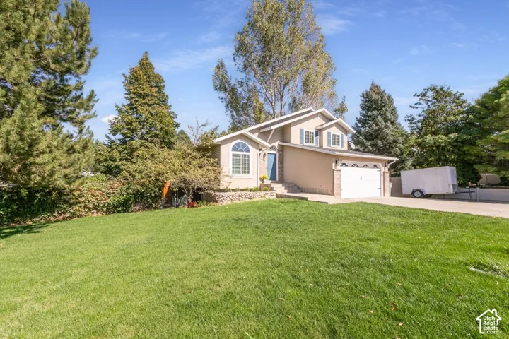 Two-story residence featuring a two-car garage, arched window, and prominent front door