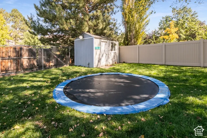 Fenced backyard with a storage shed, chain-link fence, and privacy fencing