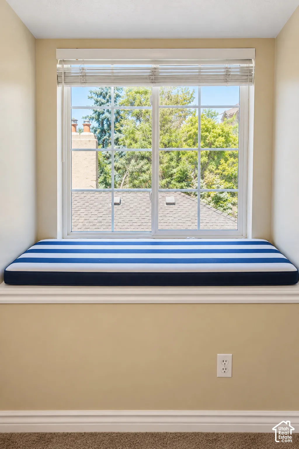 Bright window seat featuring multiple panes with natural light exposure, navy and white striped cushioning, and sill depth ideal for seating or display