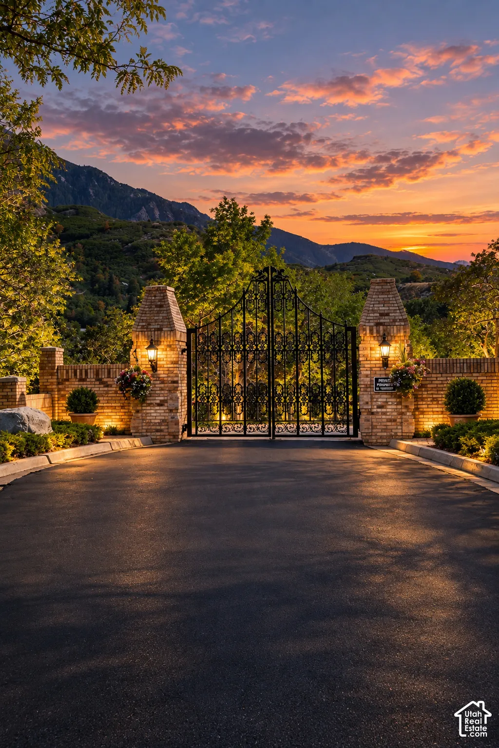 Wrought iron gates flanked by brick columns with integrated lighting
