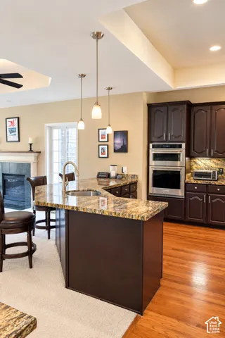 Chef's kitchen featuring a large center island with granite countertop, dual pendant lighting, and stainless steel double wall ovens