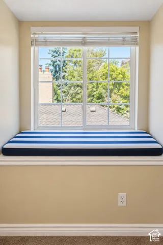Bright window seat featuring multiple panes with natural light exposure, navy and white striped cushioning, and sill depth ideal for seating or display