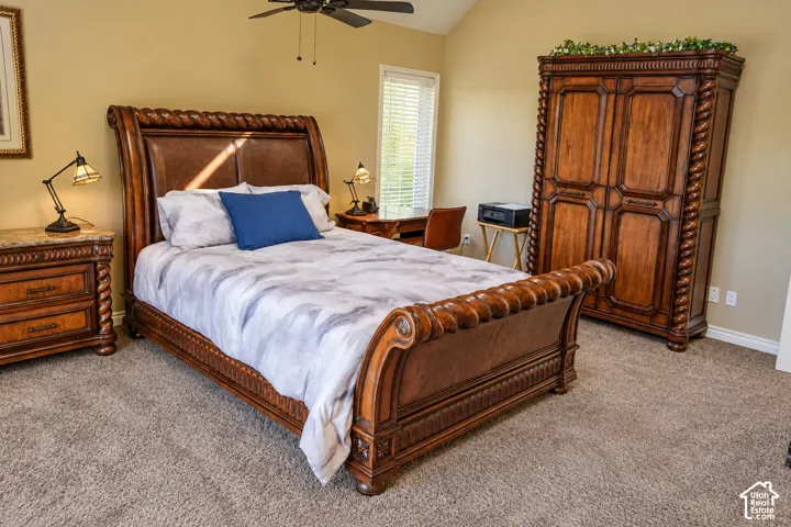 Carpeted flooring with sloped ceiling, and a ceiling fan with light fixture