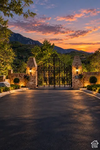 Wrought iron gates flanked by brick columns with integrated lighting