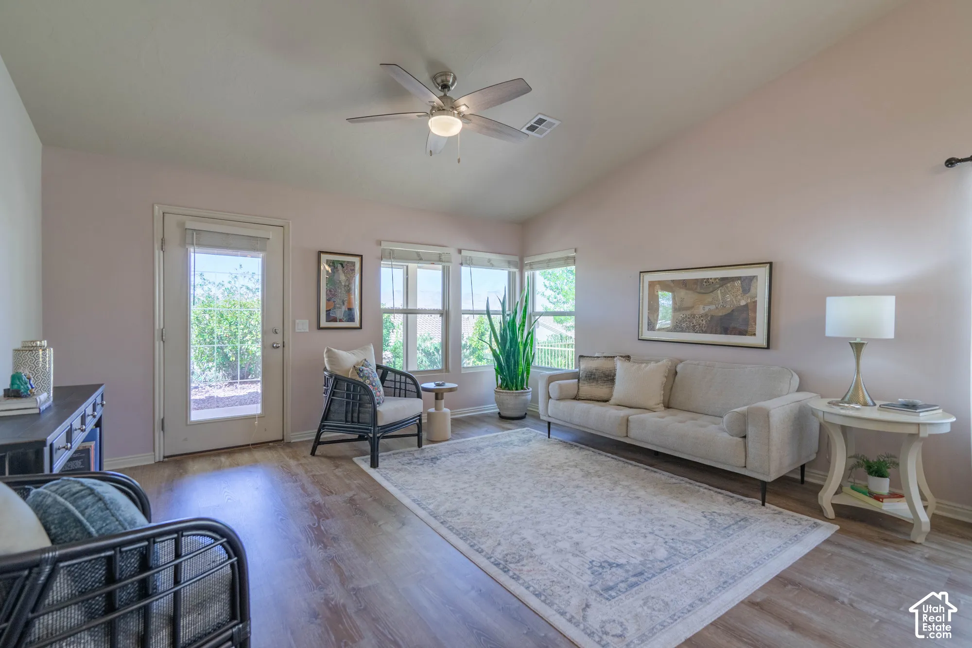 Vaulted ceiling with ceiling fan, wood-finish LVP flooring, multiple  NEW windows, and a glass-paneled exterior door