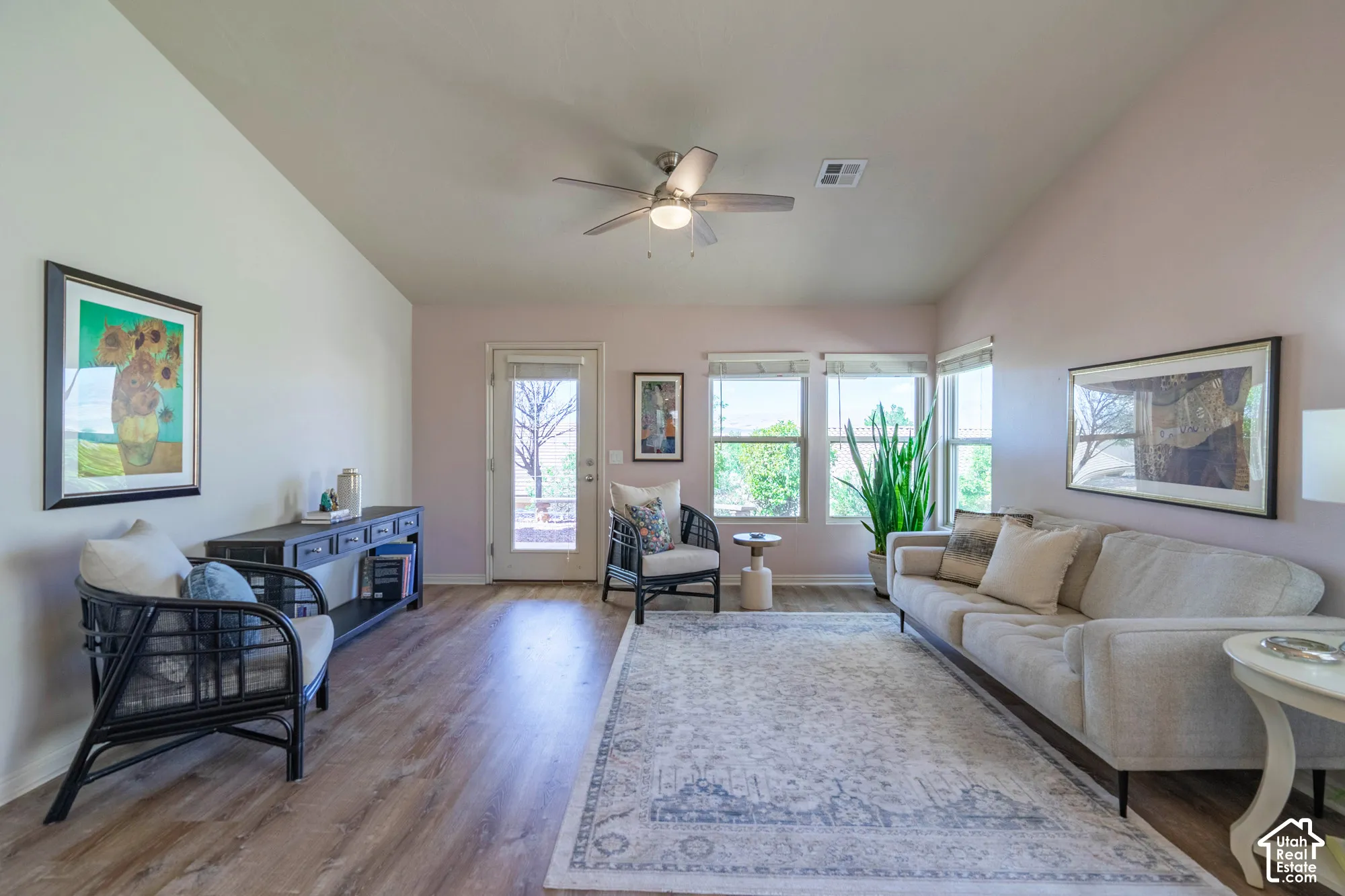 Wood-finish LVP flooring, vaulted ceiling with a ceiling fan, rear door with a full-light panel, and multiple NEW windows