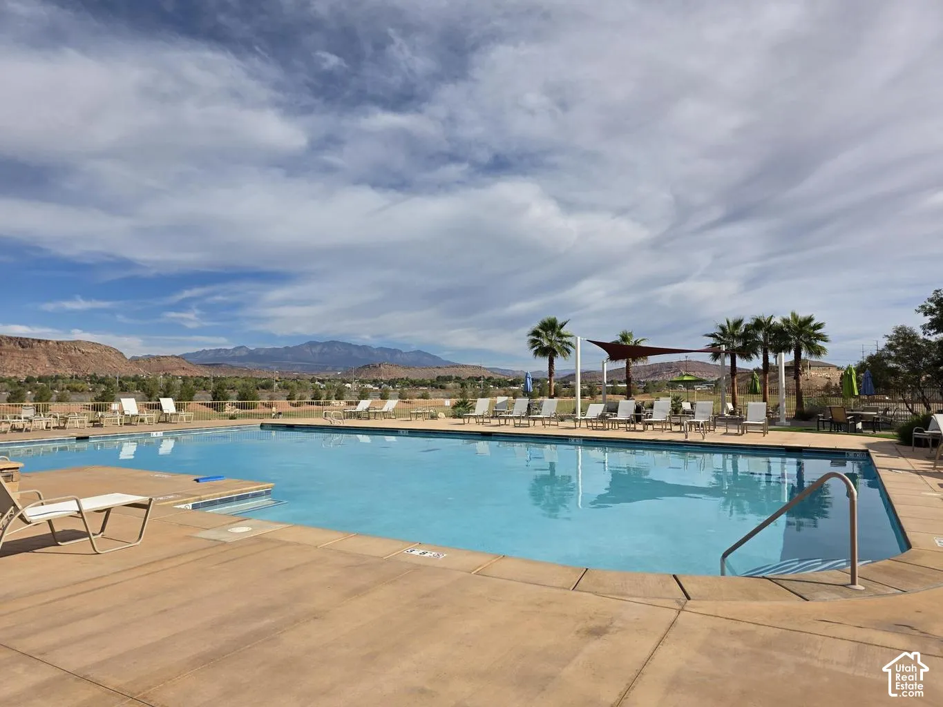 Expansive outdoor swimming pool with integrated steps, surrounded by a concrete deck