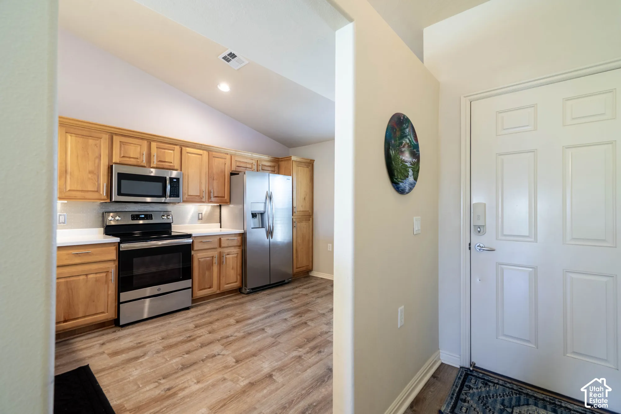 Kitchen featuring wood-finish cabinetry, stainless steel appliances, white countertops, and recessed lighting