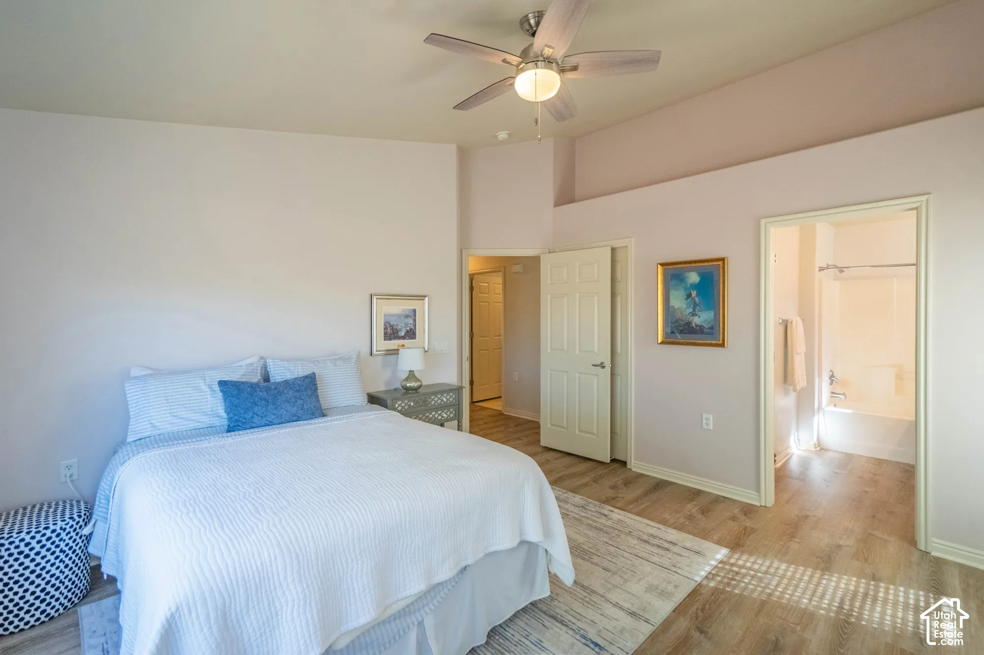 Primary Bedroom & Bathroom Vaulted ceiling with an attached ceiling fan, wood-finish flooring, and an adjoining bathroom featuring a shower-over-tub combination