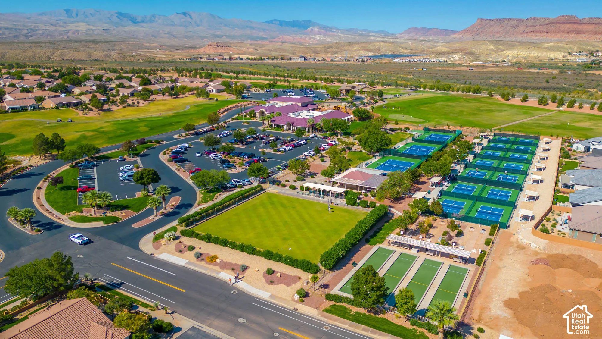 Expansive community amenities with multiple tennis courts, lawn bowling greens, a large parking area, and a golf course