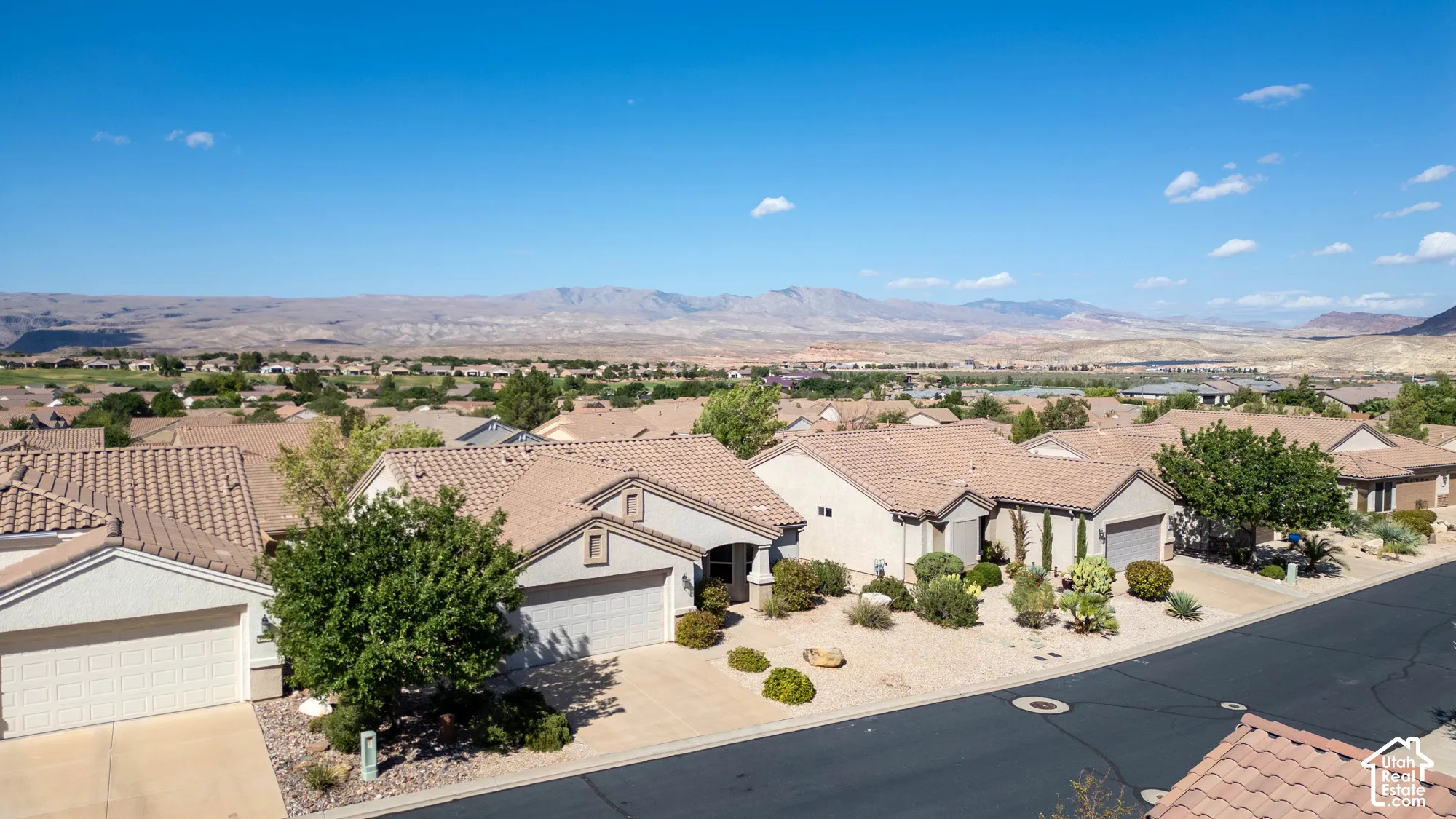 Single-story residence featuring a tile roof, an attached two-car garage, and desert-inspired landscaping