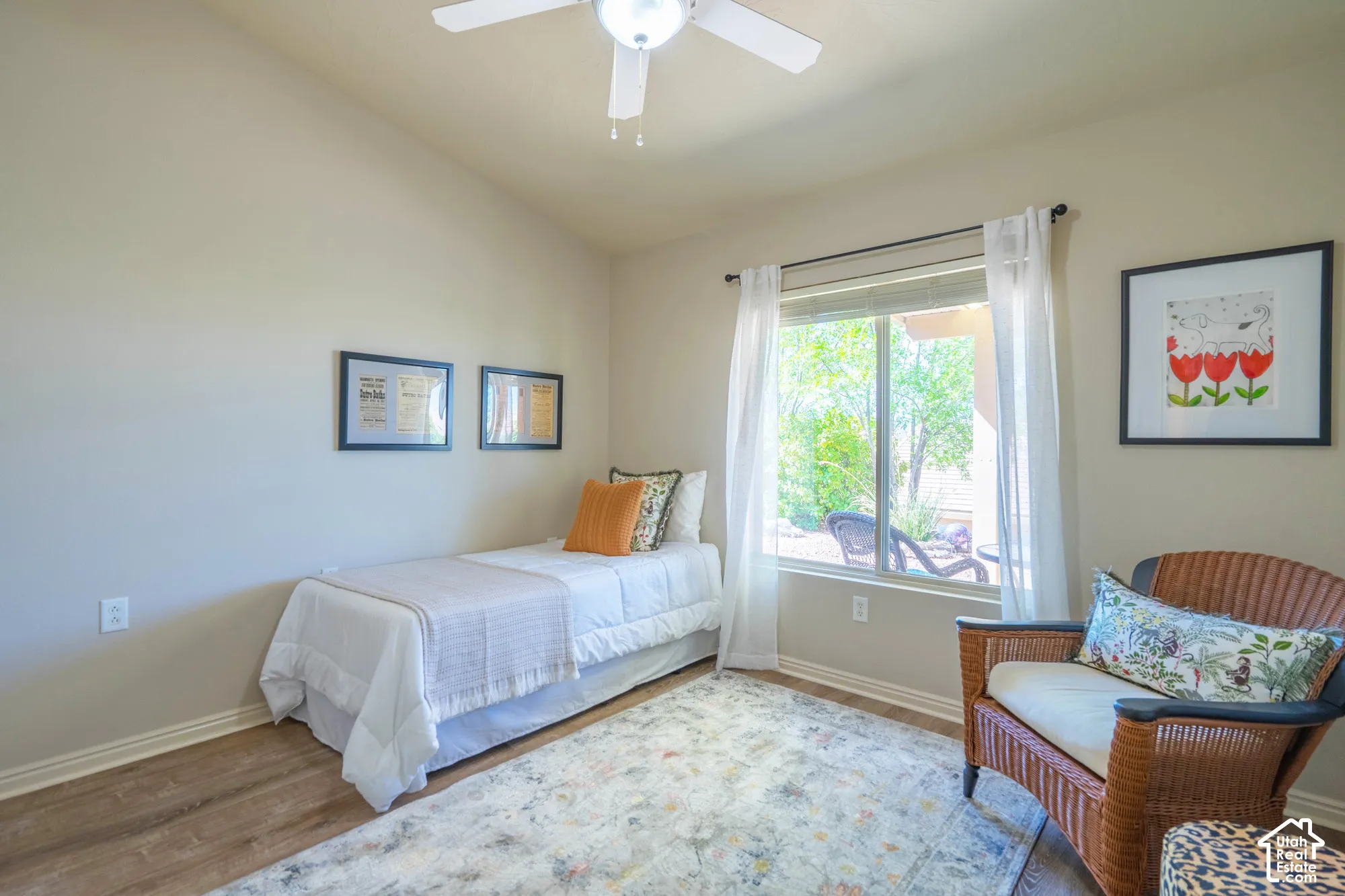 2nd Bedroom with Vaulted ceiling, a ceiling fan, wood-finish LVP flooring, and a large window with white sheer curtains