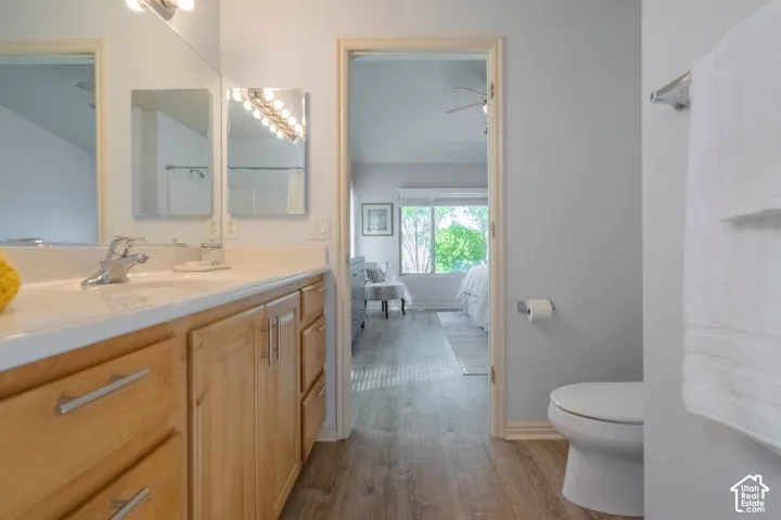 Dual vanity with light wood-finish cabinetry, chrome hardware, and integrated sinks in Primary Bathroom