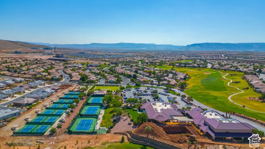 Expansive golf course, multiple tennis courts, and residential development with surrounding desert landscape