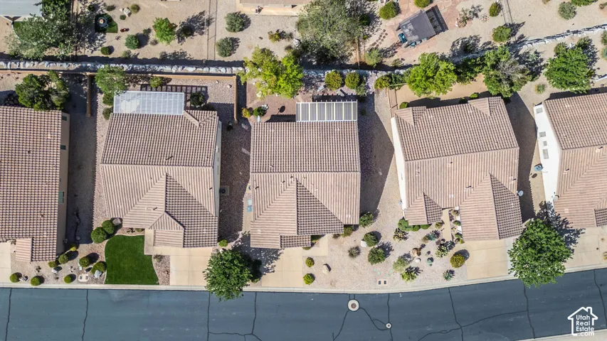 Tile roof with multiple gables, front yard with manicured lawn, and mature desert landscaping