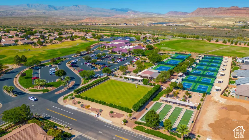 Expansive community amenities with multiple tennis courts, lawn bowling greens, a large parking area, and a golf course