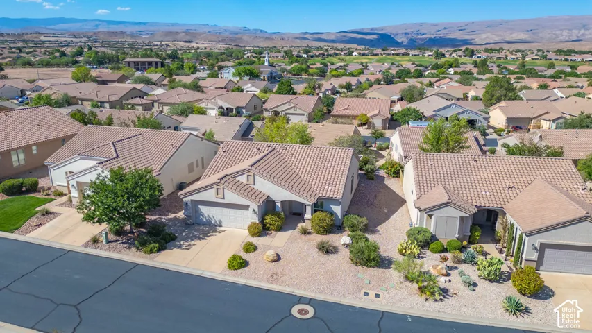 Residential neighborhood featuring numerous single-story homes, tiled roofing, and arid landscaping