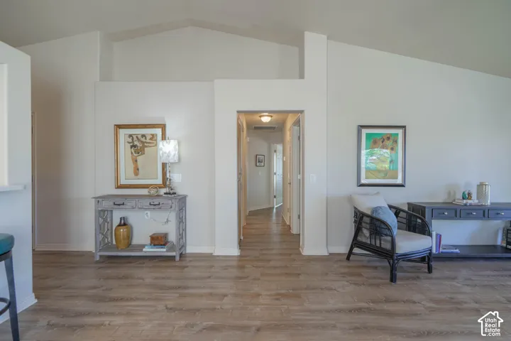Vaulted ceilings, wood-finish flooring, and recessed lighting.  Hallway to Bedrooms
