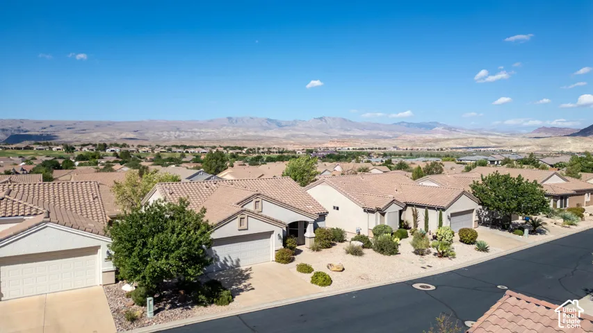 Single-story residence featuring a tile roof, an attached two-car garage, and desert-inspired landscaping