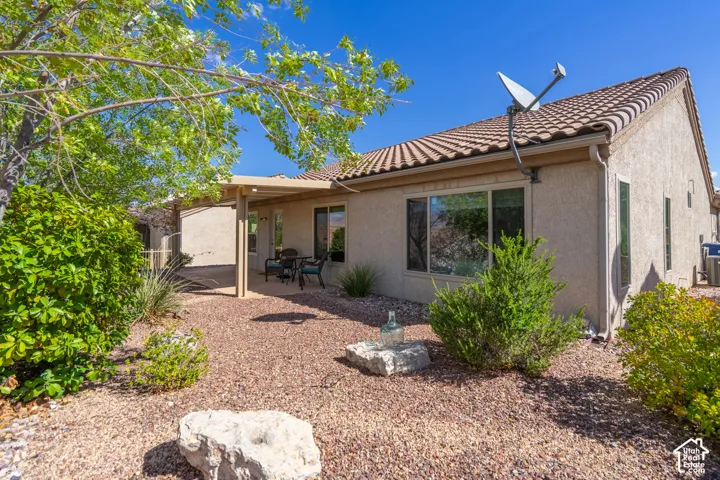 Exterior with stucco finish, tile roof, and covered patio area