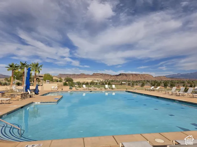 Expansive outdoor pool with integrated spa, surrounded by a paved deck