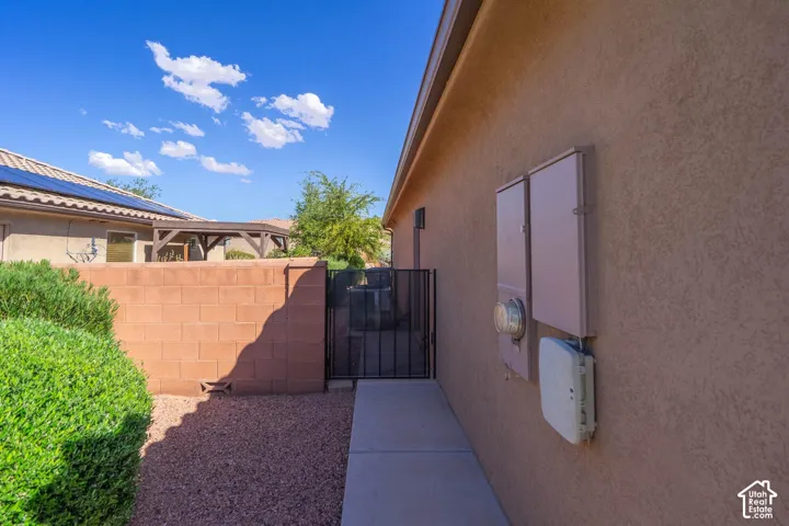 Backyard retreat featuring a concrete pathway, decorative rock landscaping, and mature shrub plantings