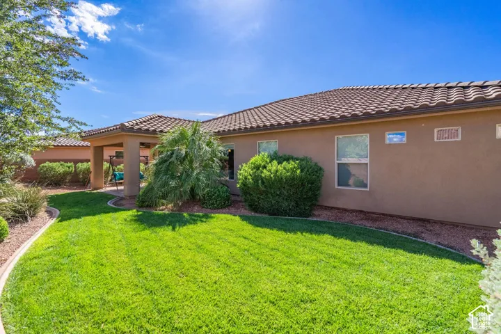 Lush manicured lawn with mature landscaping, including vibrant shrubs and desert vegetation
