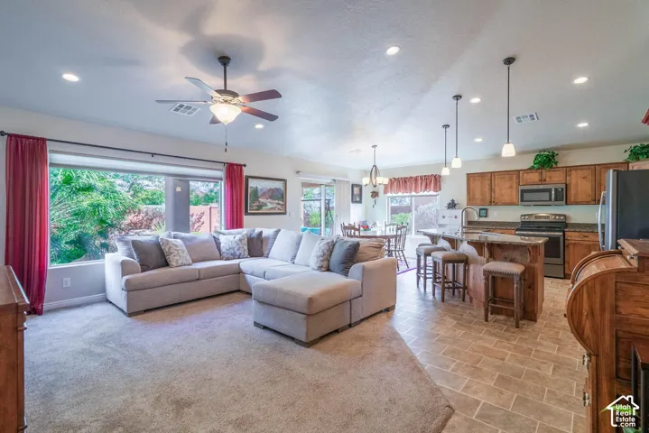 Open concept living area with carpet flooring, recessed lighting, and a ceiling fan