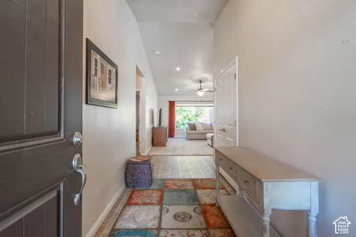 Vaulted entryway featuring panel door and tile flooring