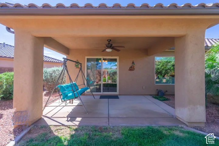 Covered patio with stucco columns and ceiling fan, concrete flooring, and direct access to the home via glass sliding doors