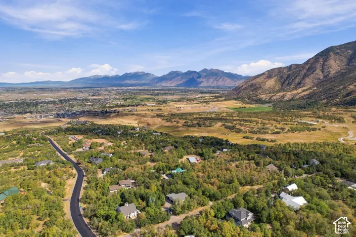 Expansive landscape featuring distant mountains and a valley, with scattered residential properties