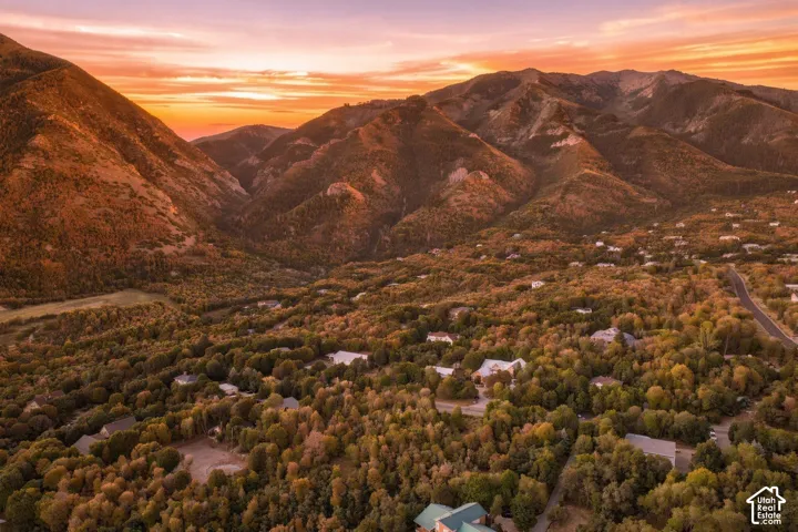 Mountainous terrain, verdant tree cover, residential structures, and a prominent road system