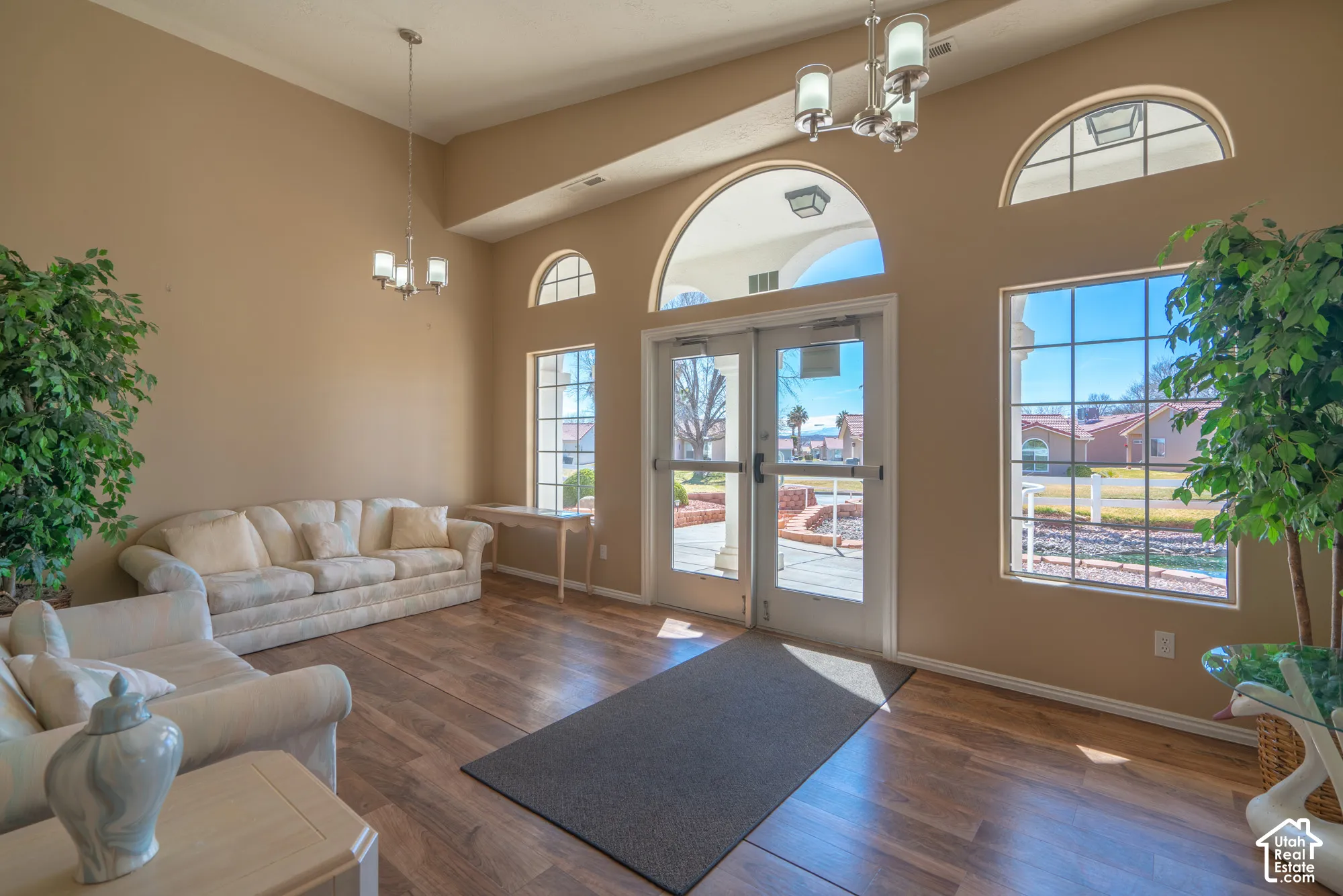 Wood-finish flooring with high ceilings, featuring transom windows and glass panel doors