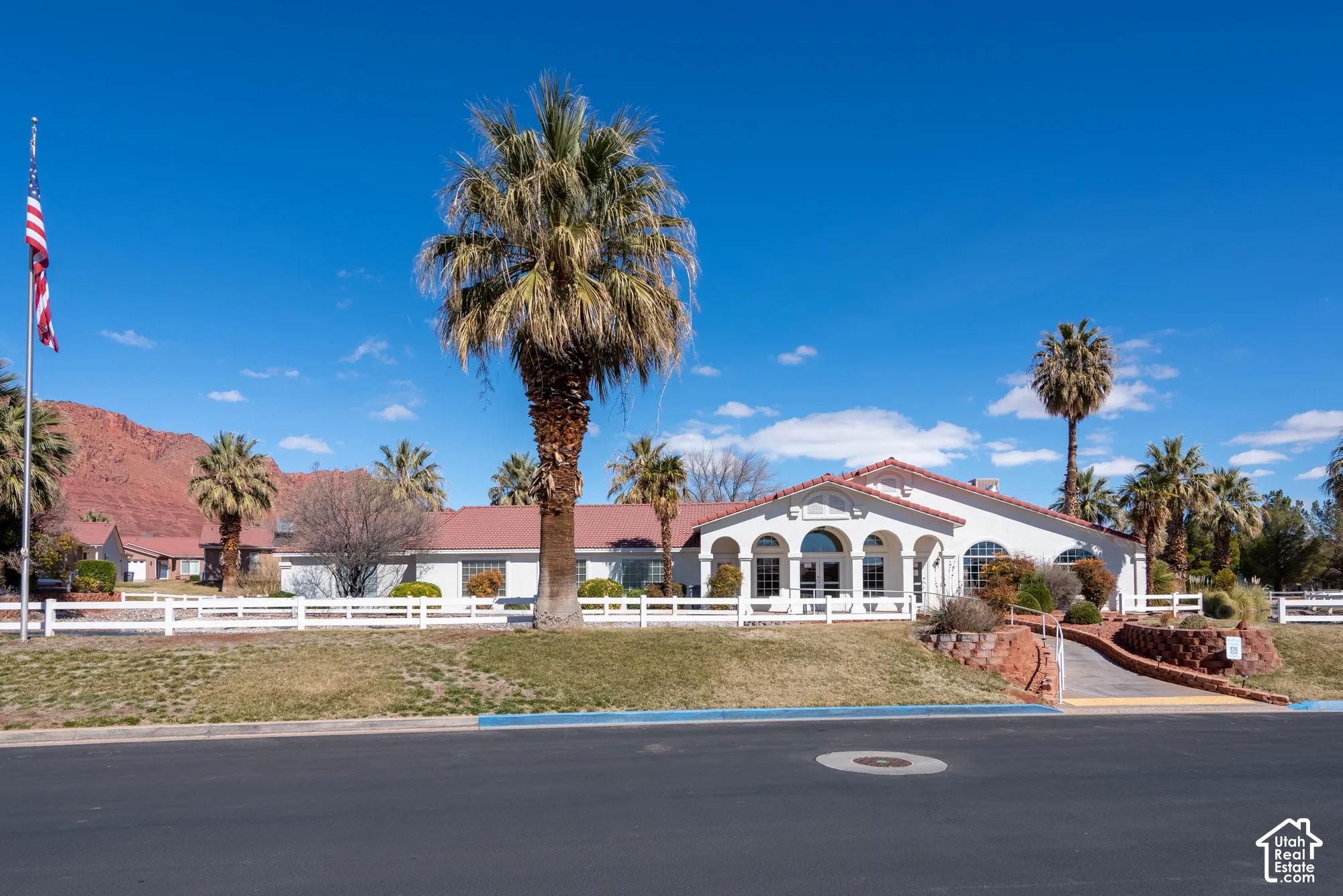 White stucco exterior with a red tile roof, arched windows, and a prominent arched entryway