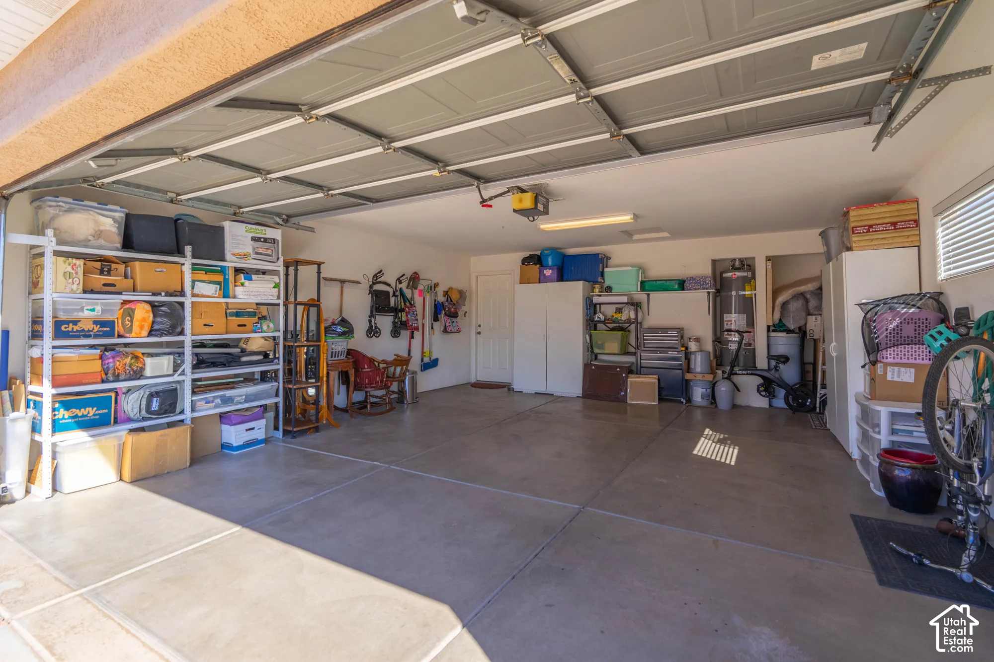Spacious garage with sectional overhead door, concrete flooring, and ample lighting