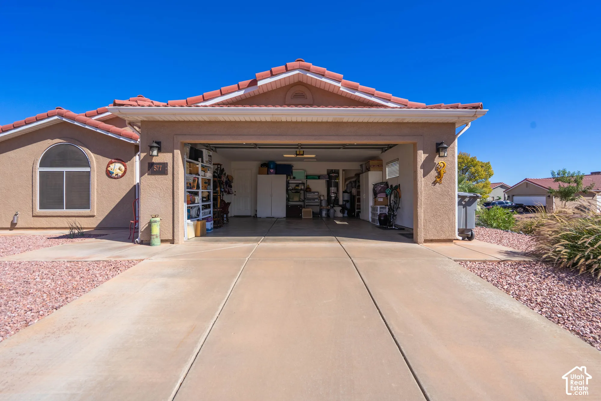 Stucco exterior featuring a tiled roof and an attached garage