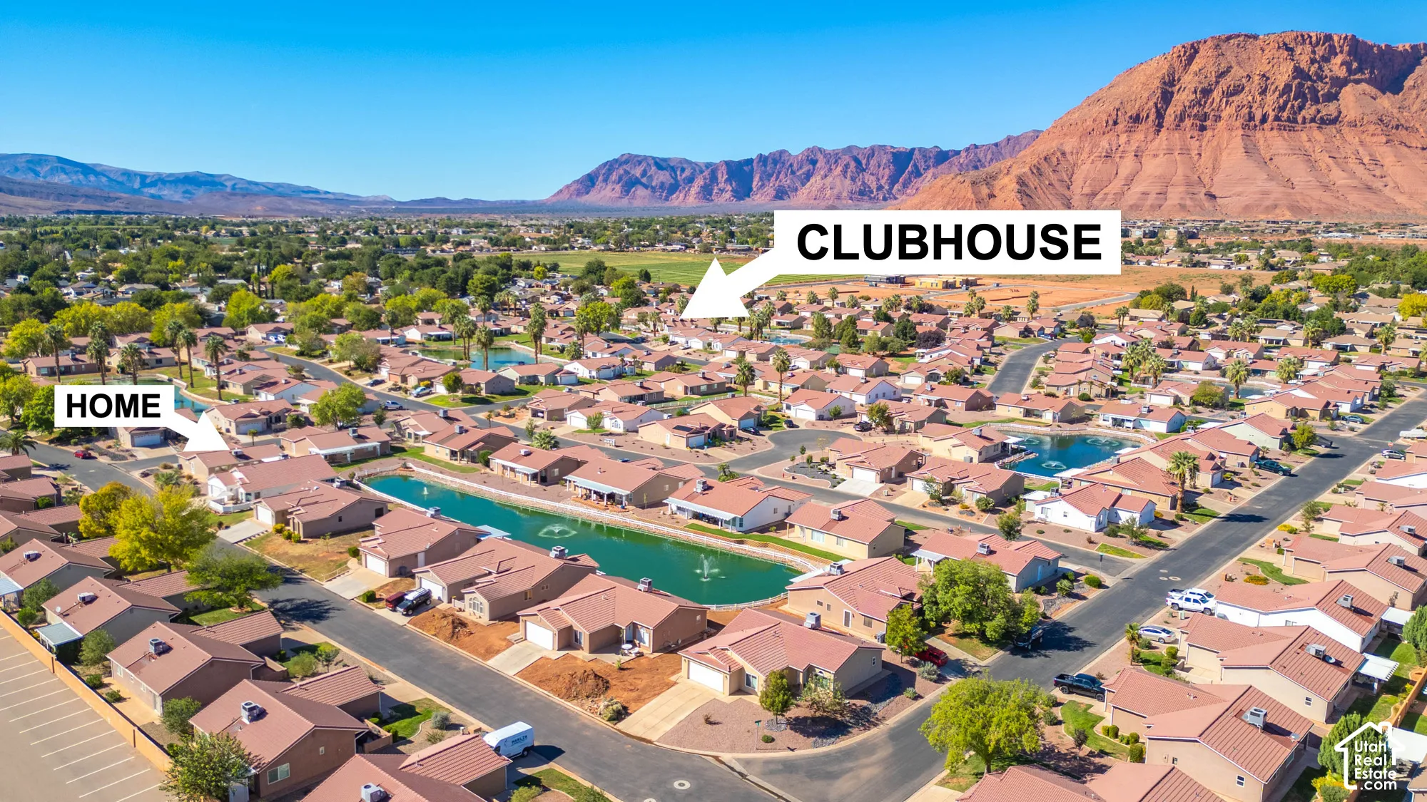 Residential community with mature landscaping, water features, and mountain backdrop