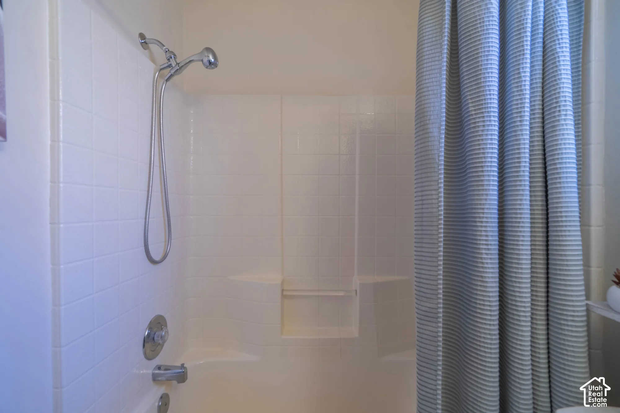 Tub and shower combination with a flexible showerhead and integrated shelving