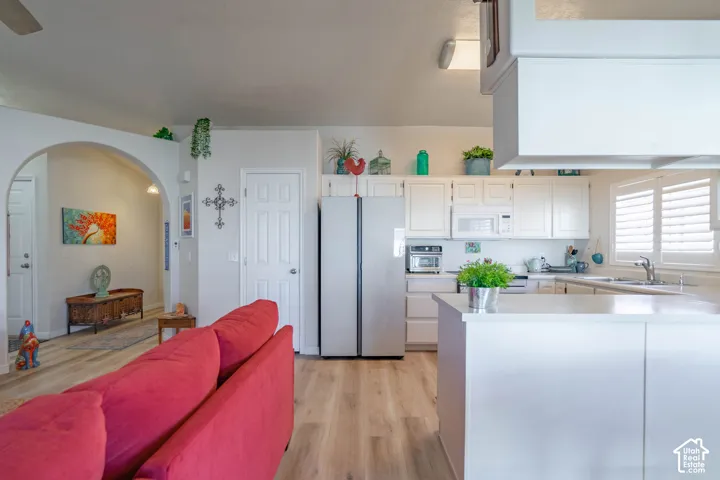 Kitchen featuring white cabinetry, light countertops, and a stainless steel refrigerator