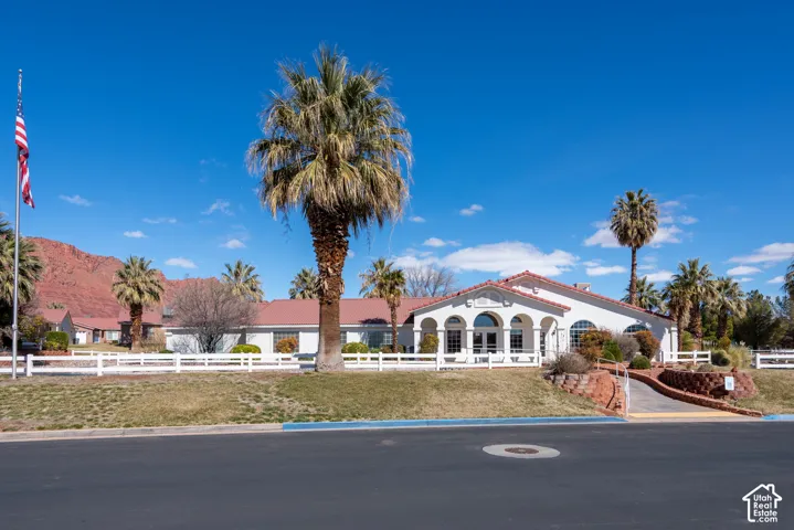 White stucco exterior with a red tile roof, arched windows, and a prominent arched entryway