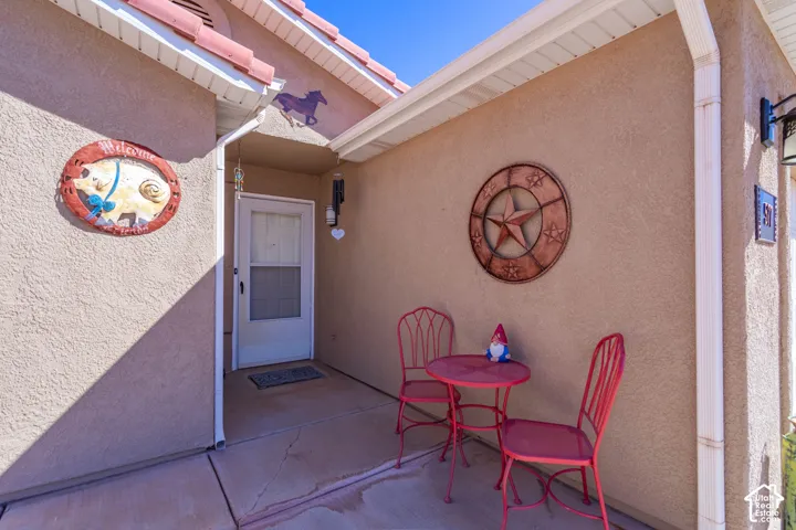 Stucco exterior with a tiled roof, covered entry, and exterior lighting fixture