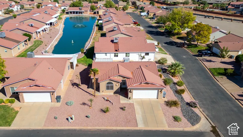 Southwestern-style residence featuring a tile roof, an attached garage, and a desert-landscaped front yard