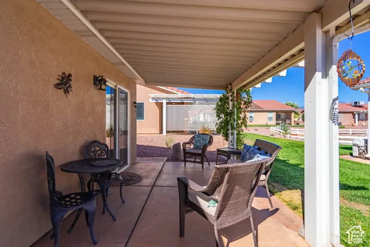 Covered patio with concrete flooring, stucco exterior, and sliding glass doors