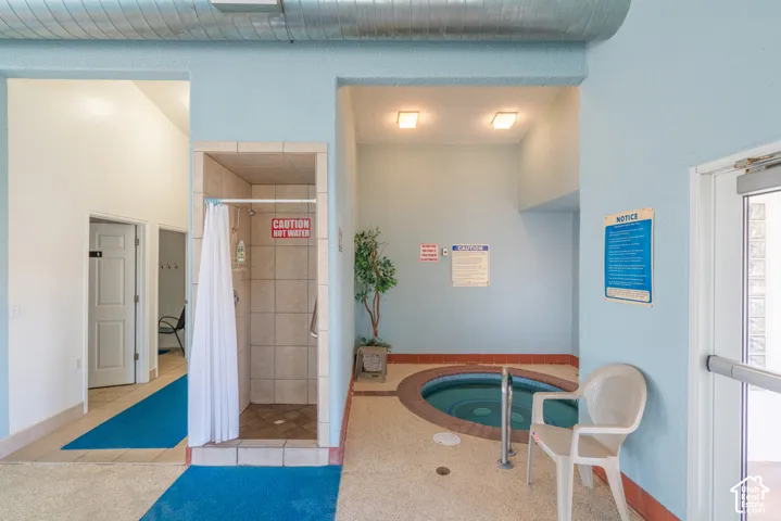 Tiled shower stall with an integrated showerhead and a built-in hot tub