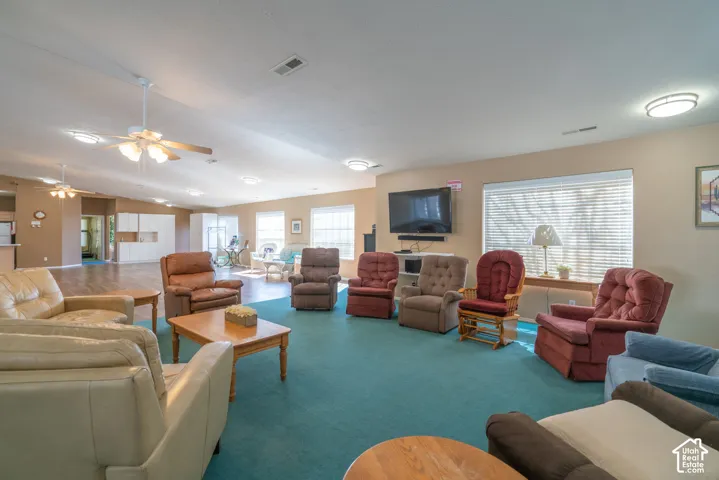 Spacious common area featuring recessed lighting, ceiling fans, wood-finish flooring, and multiple windows