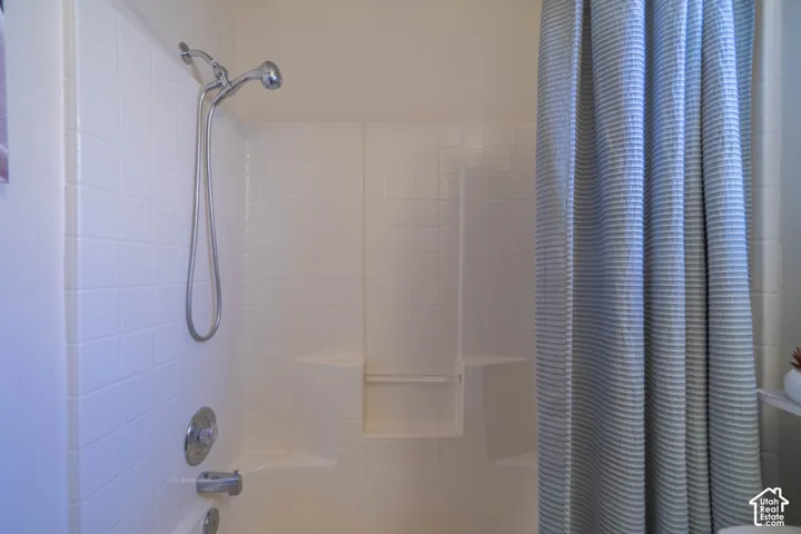 Tub and shower combination with a flexible showerhead and integrated shelving