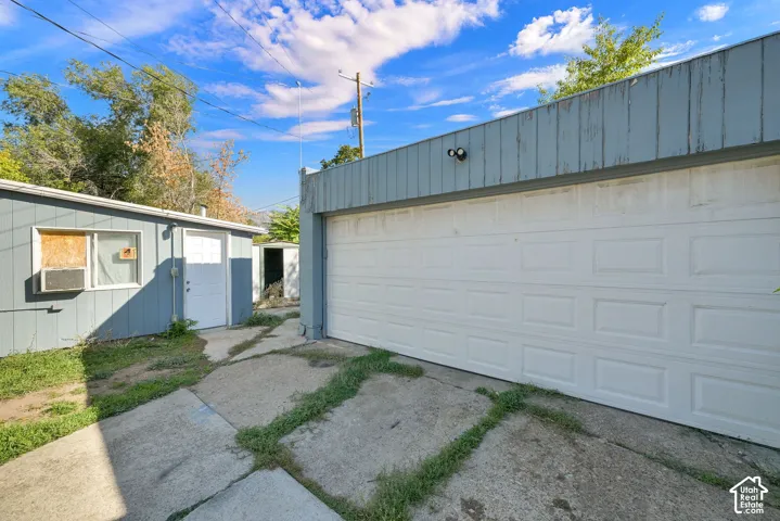 Concrete drive leading to a white panel garage door