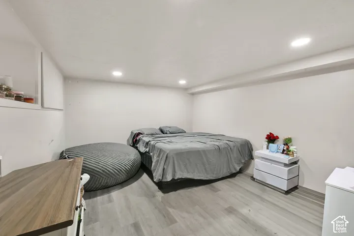 Recessed ceiling lighting, wood-finish flooring, and white walls